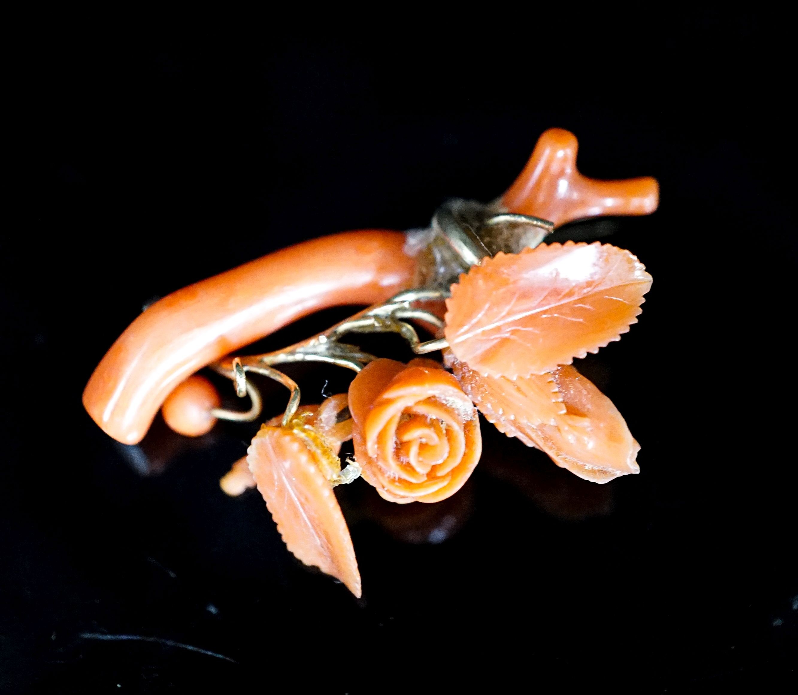 A Victorian carved coral and yellow metal mounted brooch, 40mm, gross 5.9 grams.